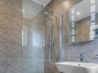 a bathroom with a shower and a sink and a mirror at A'chrannchuir in Blackwaterfoot