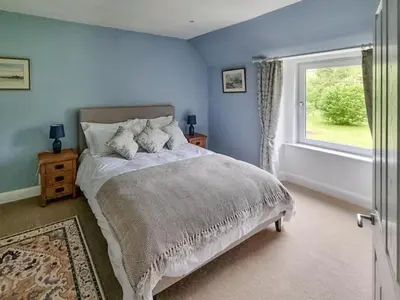 a bedroom with a large bed and a window at Lady Farm in Girvan