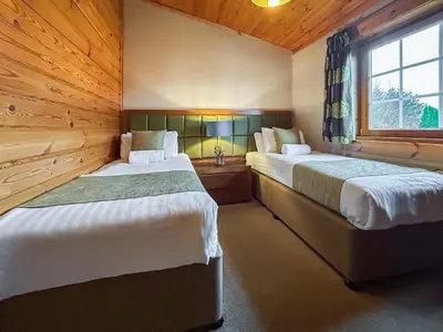 a bedroom with two beds and a window at Lodge 4 - Uk51264 in Glasgow
