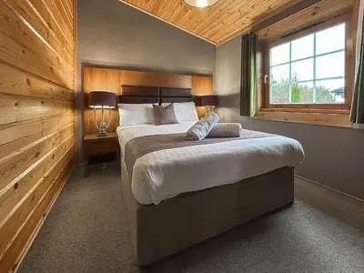 a bedroom with a large bed and a window at Lodge 5 - Uk51251 in Glasgow