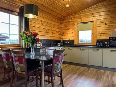 a kitchen with a table with a vase of flowers on it at Lodge 5 - Uk51251 in Glasgow
