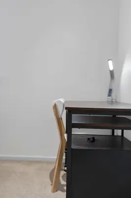 a wooden desk with a chair next to a table at Stylish 3-Bed Home with Private Garden in Airdrie in Airdrie
