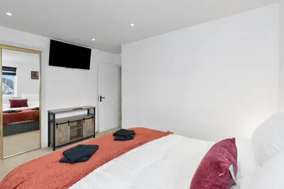 a bedroom with a large bed and a television at Stylish 3-Bed Home with Private Garden in Airdrie in Airdrie