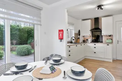 a kitchen and dining room with a table and chairs at Stylish 3-Bed Home with Private Garden in Airdrie in Airdrie