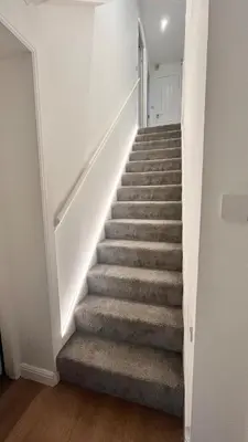a staircase in a home with white walls at Modern 5 bedroom Getaway Free Parking in Hurlet