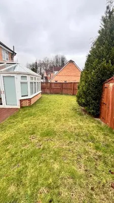 a yard with a fence and a backyard with a house at Modern 5 bedroom Getaway Free Parking in Hurlet