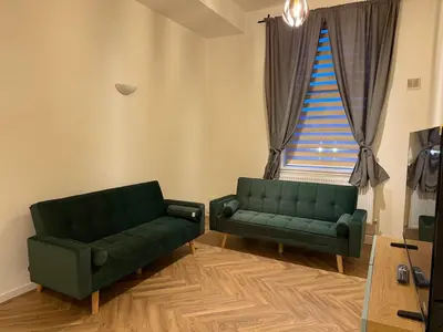 two green couches in a living room with a window at Acorn Spacious Stay Glasgow in Glasgow