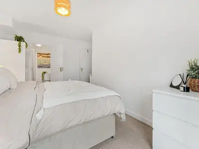 a white bedroom with a bed and a white dresser at Modern 2-Bedroom Apartment with Free Parking in Warrington in Moffat