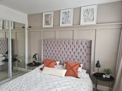 a bedroom with a large white bed with orange pillows at Modern apartment on the river in Callander in Callander