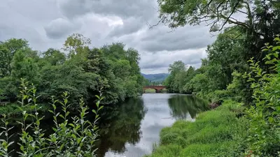 a river with a bridge in the middle of it at Modern apartment on the river in Callander in Callander