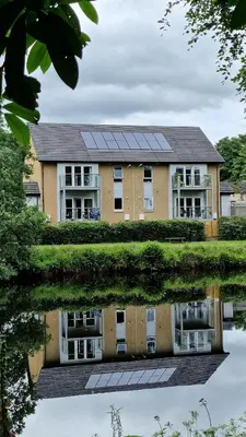 a building with solar panels on the side of it at Modern apartment on the river in Callander in Callander
