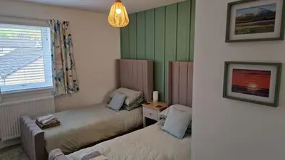 a room with two twin beds and a window at Modern apartment on the river in Callander in Callander