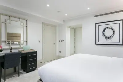 a white bedroom with a desk and a bed and a desk at Luxury 2BR Park Lane Apartment Mayfair Sleeps 6 PL15B in Moffat