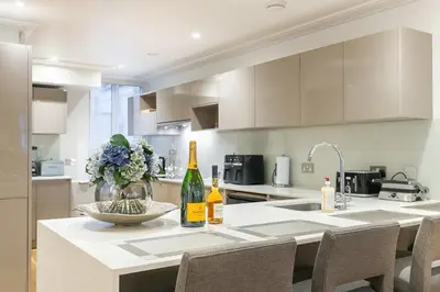 a kitchen with a table with two bottles of wine at Luxury 2BR Park Lane Apartment Mayfair Sleeps 6 PL15B in Moffat