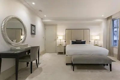 a bedroom with a bed and a desk and a mirror at Luxury 2BR Park Lane Apartment Mayfair Sleeps 6 PL15B in Moffat
