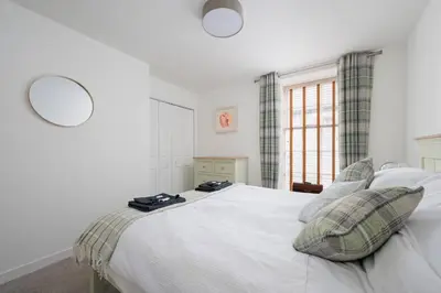a bedroom with a large white bed and a window at Historic 1BR Home in Culross Near Filming Sites in Culross