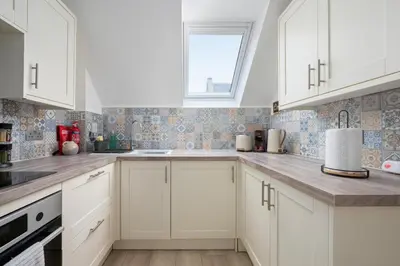 a kitchen with white cabinets and a window at Historic 1BR Home in Culross Near Filming Sites in Culross