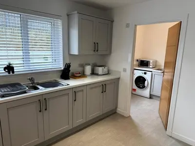 a kitchen with white cabinets and a sink and a microwave at Luxury 4BR Detached Exec Home in Cadzow