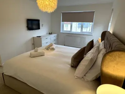 a large bed in a bedroom with a couch at Luxury 4BR Detached Exec Home in Cadzow