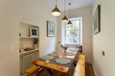a dining room with a wooden table and a window at Old Argyll House in Rashfield