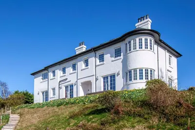 a large white building on top of a hill at Oban Bay Hall in Dunollie