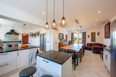 a kitchen and living room with a table and a dining room at Oban Bay Hall in Dunollie