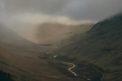 a valley with a river in the middle of a mountain at Auch - Cottages in Bridge of Orchy