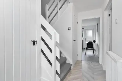 a white hallway with a staircase in a house at Contractor & Family Friendly House - Sleeps 8 - FREE Parking and Fast Wi-Fi in Uphall