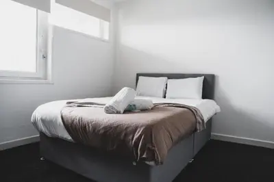 a bed with white pillows and a window in a room at Glenraith property in Hogganfield