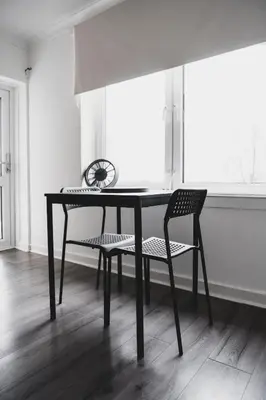 a black table and chair in a room with a window at Glenraith property in Hogganfield