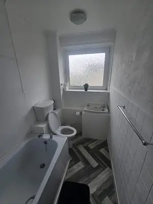 a white bathroom with a toilet and a window at Glenraith property in Hogganfield