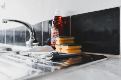 a kitchen sink with a bottle of detergent and a sponge at Glenraith property in Hogganfield