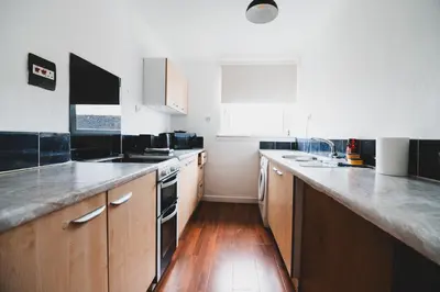 a kitchen with wooden cabinets and a counter top at Glenraith property in Hogganfield