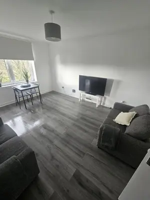 a living room with a couch and a flat screen tv at Glenraith property in Hogganfield