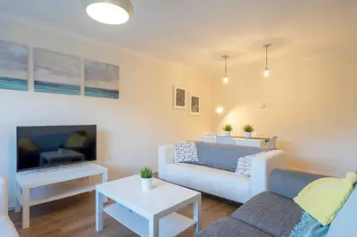 a living room with a couch and a tv at Tranquil 2 Bed Flat, Free Parking, near Murrayfield & City Centre in Edinburgh