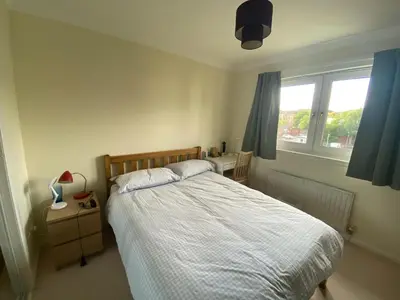 a bedroom with a bed and a desk and a window at Modern central 2 bedroom flat with private parking in Glasgow