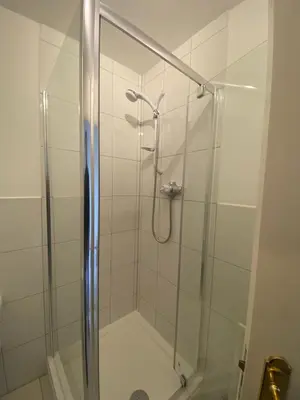 a bathroom with a shower with a glass door at Modern central 2 bedroom flat with private parking in Glasgow