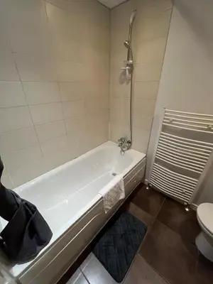 a white bath tub in a bathroom with a toilet at City centre stylish apartment in Glasgow