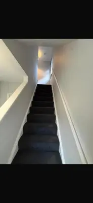 a staircase leading up to a room with a light at Beautiful modern self-contained house in Moffat