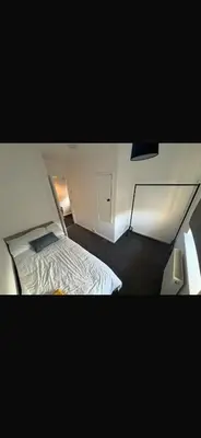 a small bedroom with a bed and a desk at Beautiful modern self-contained house in Moffat