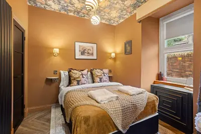 a bedroom with a bed with a floral ceiling at Boutique Studio Near Stirling in Cambusbarron