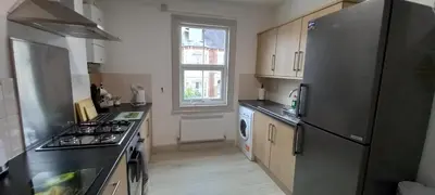 a kitchen with a stainless steel refrigerator and a window at Town centre 3 bedroom flat in Moffat