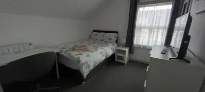 a small bedroom with a bed and a television at Town centre 3 bedroom flat in Moffat