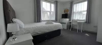 a bedroom with a bed and a desk with a desk at Town centre 3 bedroom flat in Moffat