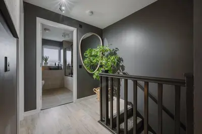 a hallway with a staircase and a bathroom with a mirror at JW Canmore ApartHouse in Glasgow