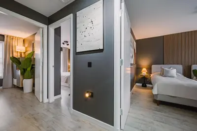 a bedroom with a bed and a wall with a picture at JW Canmore ApartHouse in Glasgow