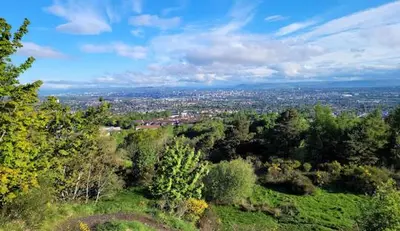 a view of a city from a hill with trees at Newton Mearns Home in Newton Mearns