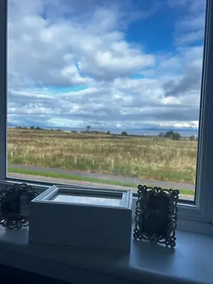 a window with a view of a field at The Beach View - Greenan in Ayr