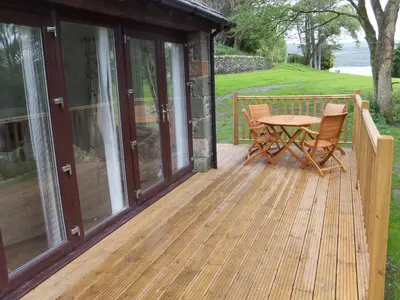 a wooden deck with a table and chairs on it at Turbine House in Lochgilphead