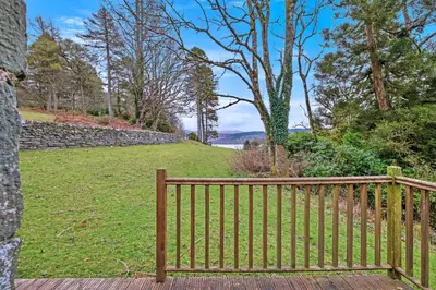 a wooden bench sitting on top of a field at Turbine House in Lochgilphead